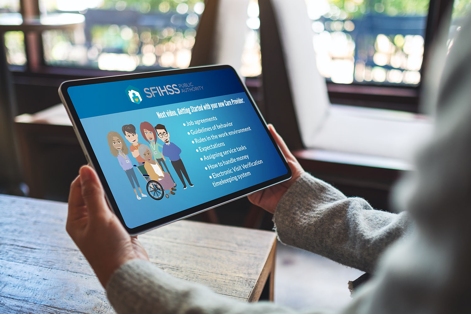 Photo close-up of a hands holding digital tablet with a SFIHSSPA video training being played on it.