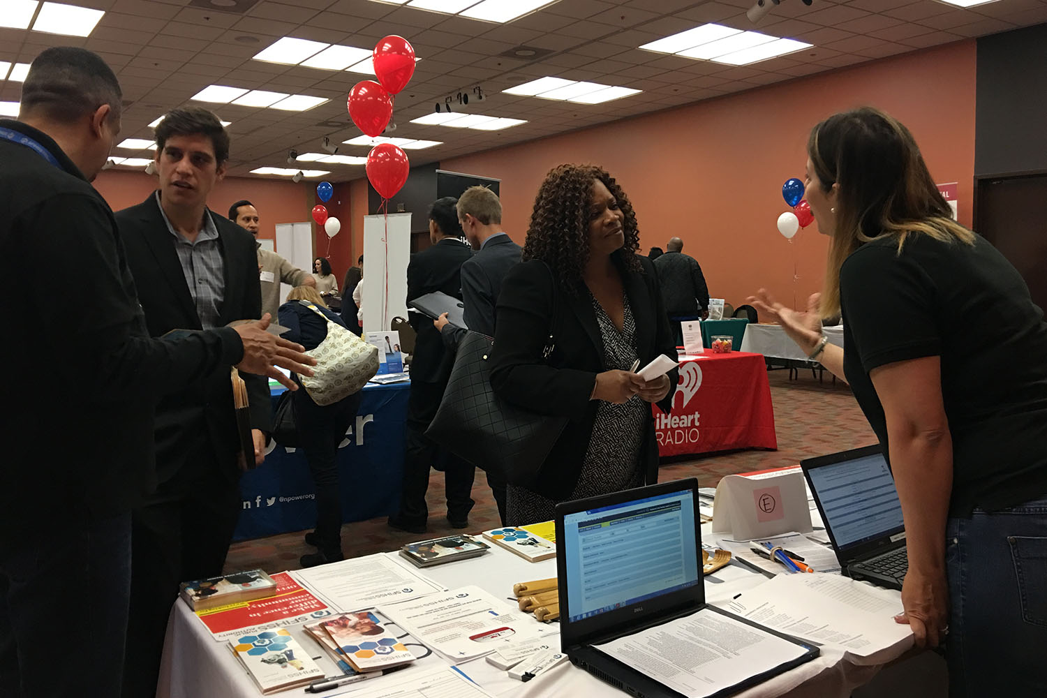 Photo of a SFIHSSPA staff member at a job reosurce fair in conversation with a female attendee at the fair.