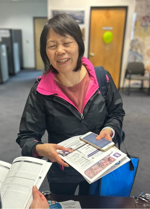 Photo of a female provider smiling and laughing while she's receiving resources at the San Francisco IHSS Public Authority.
