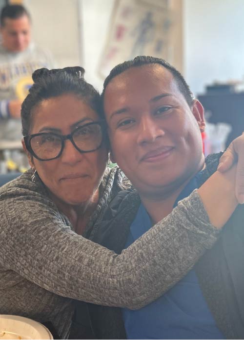 Photo of two providers in a warm embrace with each other.